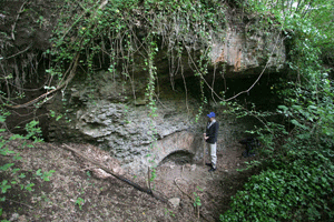 Archaeologist Katherine Rinne
stands beside a large ancient
Roman springhouse