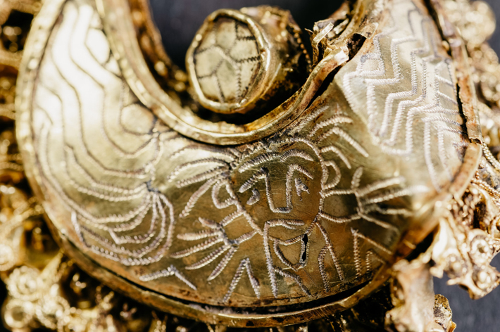 Detail of a gold ear pendant dating to the first half of the eleventh century that was discovered in the small city of Hoogwoud in the Netherlands. The decoration includes an engraved depiction of what archaeologists believe is a praying priest. (Photo © Archeologie West-Friesland/Fleur Schinning)