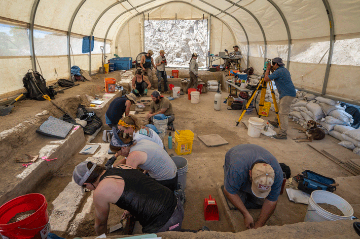 Archaeologists digging inside the excavation tent at the La Prele site work in close quarters. 