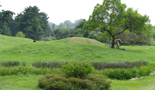 The archaeological park’s verdant, overgrown hillocks are all that remain visible of the ancient city’s structures.  Today they’re popular with picnickers and worshippers. (Roger Atwood)