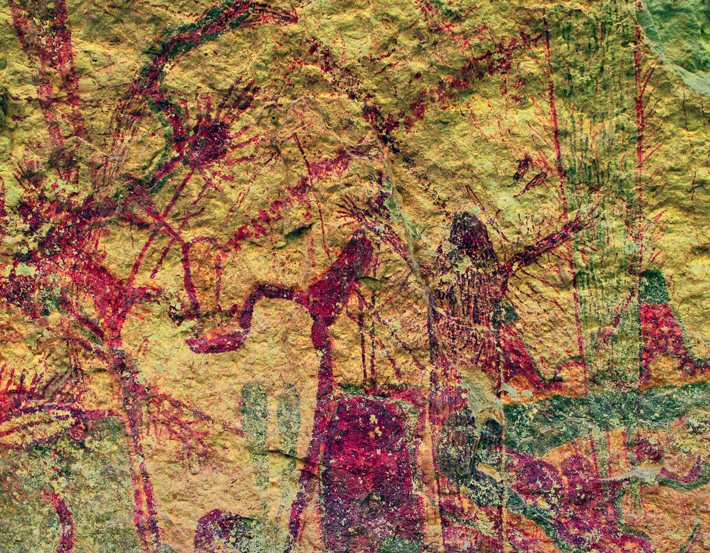 This digitally enhanced photo of a rock art panel at the site of Rattlesnake Canyon shows two figures with their arms raised. Thick streams of red dots issue from their mouths and cross one another. 
