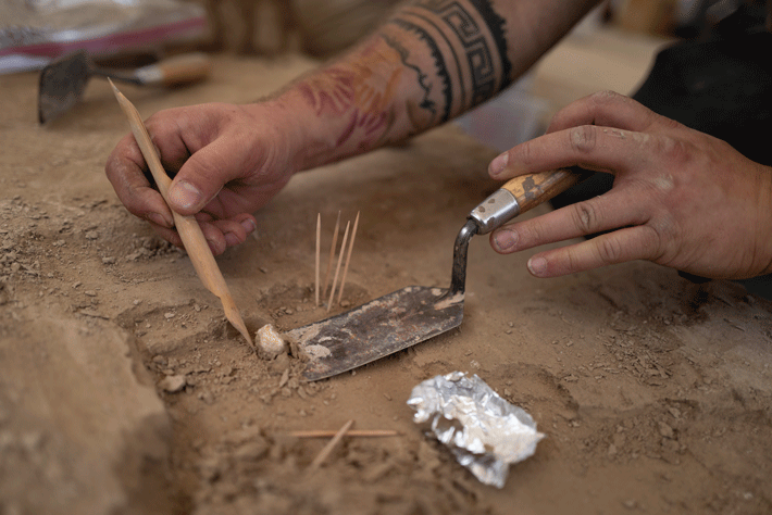 A fragment of mammoth ivory is excavated by an archaeologist. The distribution of mammoth ivory across the site suggests inhabitants had equal access to this important resource. 