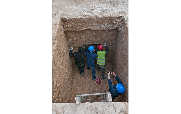 Archaeologists excavate the 2,300-year-old shaft grave of a young woman along Via Hebron on the southern outskirts of Jerusalem, Israel. (Shai Halevi, Israel Antiquities Authority)