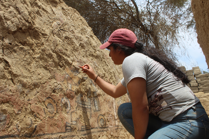 A student member of the project cleans a portion of the newly discovered Huaca Pintada mural.