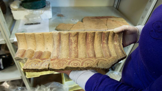 Many of the artifacts, such as this painted terracotta architectural element from a well-decorated tomb in the necropolis, have been taken to a nearby lab to be reassembled, if possible, and conserved. (Marco Merola)