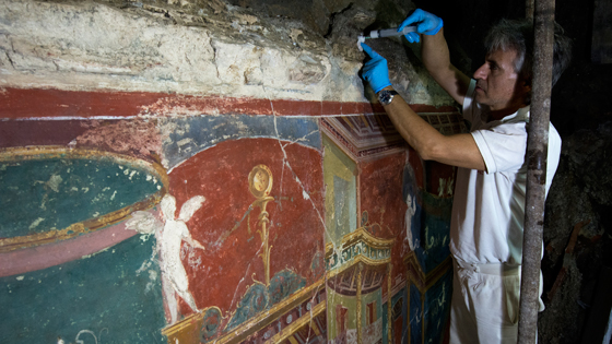 Restorer Giancarlo Sorcini prepares to inject cement to consolidate frescoes adorning the eastern wall of the villa’s triclinium, or dining room.